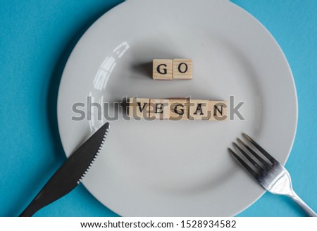 'Go Vegan' made from wooden letters on a white plate to represent concept about veganism movement  Royalty-Free Stock Photo #1528934582