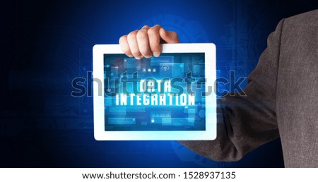 Young business person working on tablet and shows the digital sign: DATA INTEGRATION