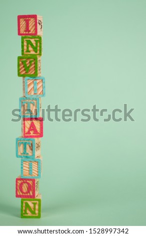 The word 'INVITATION' in coloured wooden blocks, with a light green background. Perfect for an original and funny invitation for a babyshower or another event. Including copy space for your own text.