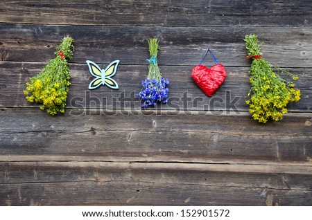 hanging medical herb bunch and red heart on wooden farm wall. Healthy lifestyle concept