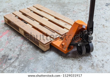 Orange pallet truck, pallet truck with empty pallet, pallet jack transport warehouse storage Royalty-Free Stock Photo #1529031917