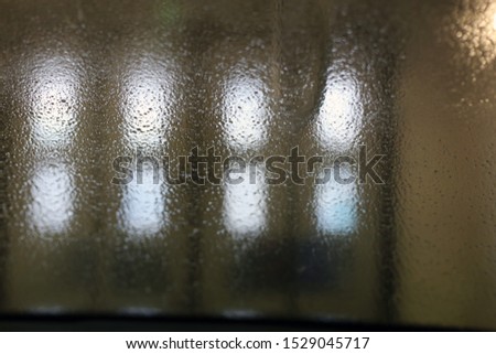 Abstract, weird, a bit creepy, and mystical photo taken in a car wash. This photo includes some water drops and blurred wall and door. Beautiful blurred texture. Colors: black, white, grey.