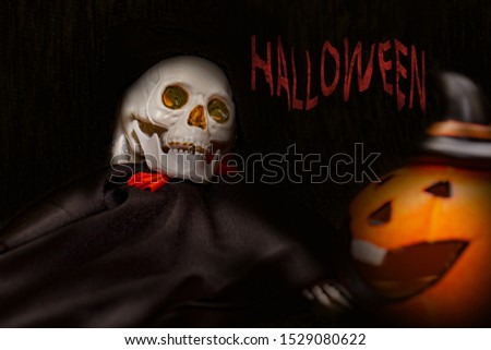 Halloween card with spooky skeleton and orange pumpkin on dark background.