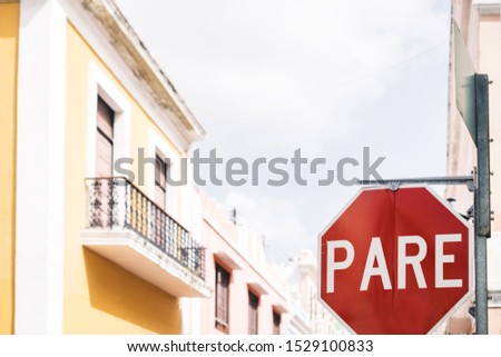 Stop / Pare traffic street sign on road intersection in residential neighborhood of old San Juan city, Puerto Rico