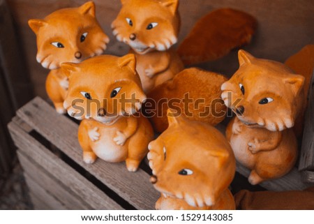 Clay foxes at a handmade local market. Cute toys, figures for home decoration. Decorative art. Selective focus. 