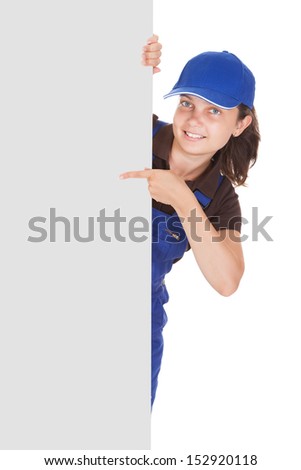 Smiling female plumber holding blank placard on white background
