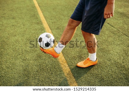 Male soccer player with ball standing on line