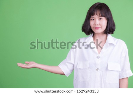 Portrait of beautiful Asian businesswoman showing something