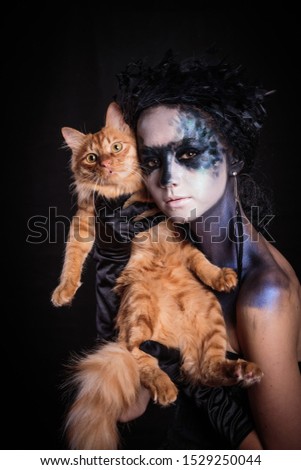 Halloween photo shoot Day of the dead on a black background with a red cat in the studio.