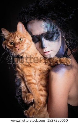 Halloween photo shoot Day of the dead on a black background with a red cat in the studio.