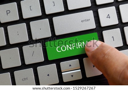 Finger pressing confirm button keypad on laptop computer. Business and finance concept. Royalty-Free Stock Photo #1529267267