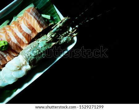Top view picture of salmon sashimi, lobster sashimi isolated on black background.