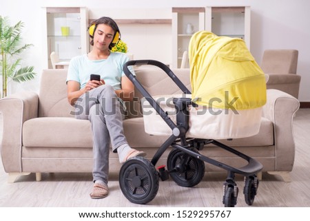 Young man looking after baby in pram