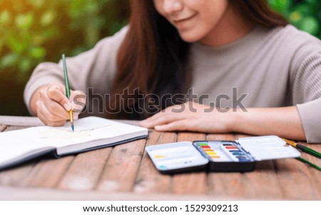 A woman drawing and painting with watercolor