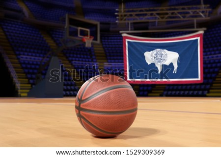 Wyoming state flag and basketball on Court Floor