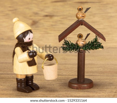 european christmas toy feed birds, wooden background
