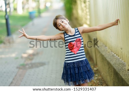 Little girl, eight years old, having fun in an urban park.