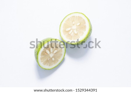 halves of fresh green lime with sheets on a light background