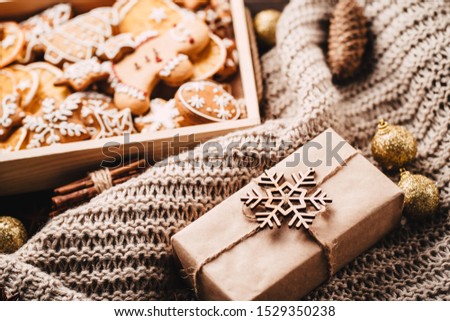 Christmas and New Year traditions concept. Gingerbread cookies, decorations, gift boxes and knitted blanket