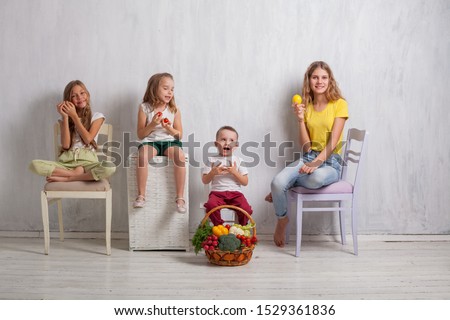 boy and three girls with a basket of vegetables and fruits
