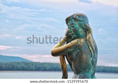 The little Mermaid statue in Hatyai beach Thailand with bluesky and copy space background.