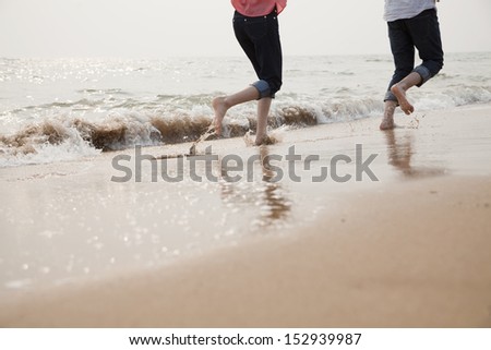 Young Couple Running in the Waves