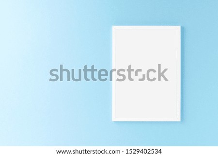 Empty picture frame on blue wall. Mockup with copyspace