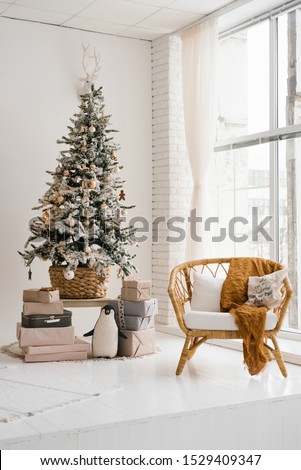 Christmas tree in the living room in bright colors, a chair from the rotunda near the floor-to-ceiling window Royalty-Free Stock Photo #1529409347