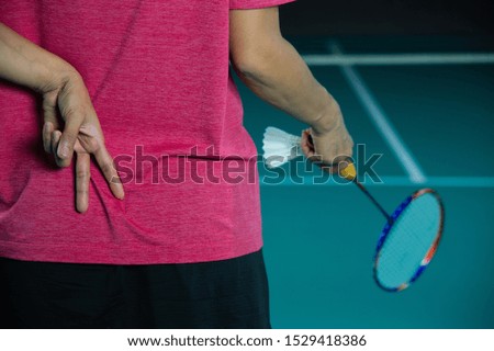Woman Badminton player holding racket and shuttlecock on right hand and make hand signal to partner, hand sign for Badminton sports, sport player making signal in game, victory sign