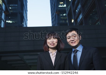 Portrait of two business people outdoors among skyscrapers in Beijing