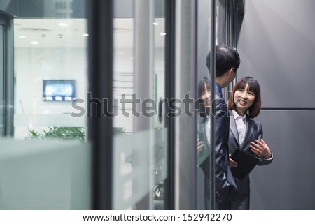 Business people talking together by a glass wall