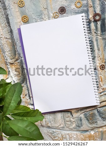 notepad on a wall with a plant and gears