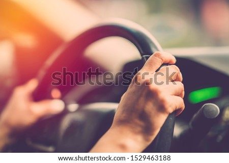 Woman hand driving car. Vintage filter Royalty-Free Stock Photo #1529463188
