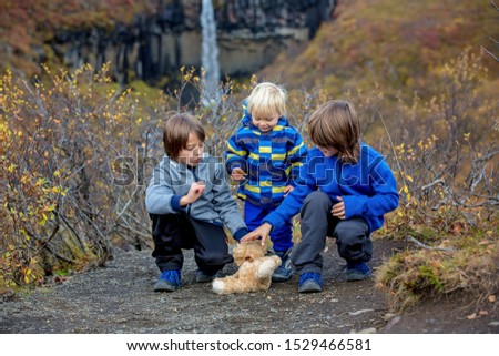 Happy children, posing in front of beautiful waterfall Svartifoss in Skaftafell national park in Iceland