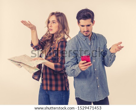 Young tourist couple consulting a city guide map and smart phone gps searching for locations looking lost and confused. Travel industry and online app advertising style image isolated on white.