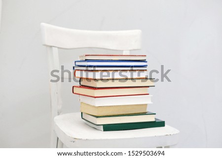 A bunch of books on a white chair