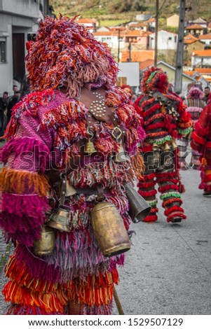 costumed people with handmade wooden mask and hanging rattles on the body in a small Hamlet in Portugal