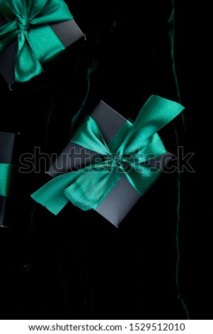 Luxury black gift boxes with green ribbon on shine velvet background. Christmas, birthday party presents. Father Day. Flat lay. Copy space. Top view.