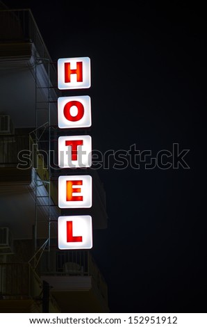 Illuminated vertical hotel sign taken at night