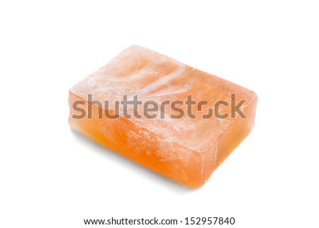 Piece of natural orange fruit soap on white background