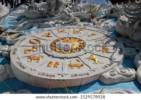 The twelve zodiac signs table with Yin Yang sign in Hatyai park background