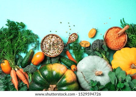 Vegan and vegetarian diet, harvest concept. Autumn vegetables, lentils, beans, raw ingredients for cooking on trendy green background. Healthy, clean eating concept. Copy space. Top view