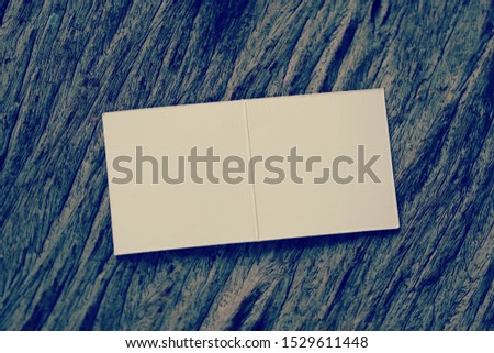 Piece of empty paper on wooden table with vintage color tone closeup blur background