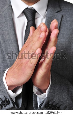 a man wearing a suit clapping his hands