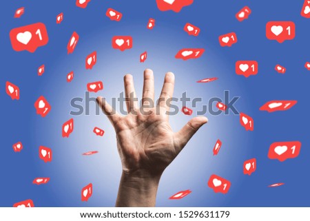 Hand rising against blue background and receiving or collecting likes - social media concept