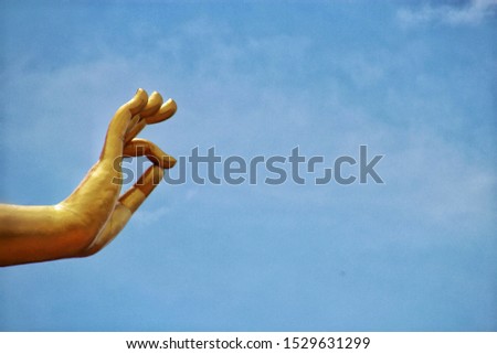 The Big hand of Buddha in Hatyai park with clound and soft bluesky background.