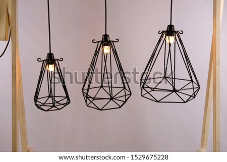three iron lamp holder hanging in the room