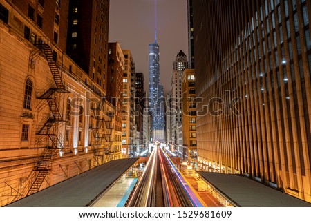 light trails of the train by night between the skyscraper building and Trump Tower in the background CHICAGO, ILLINOIS (USA)
