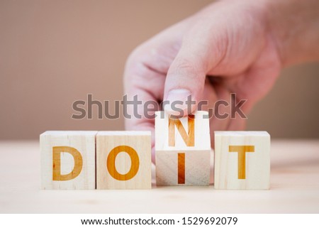 Hand flipping wooden cubes for change wording between don't to do it.Mindset for career growth business. Royalty-Free Stock Photo #1529692079