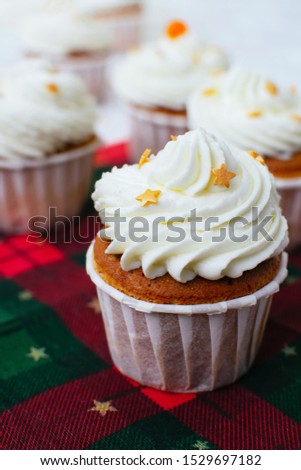 Homemade christmas cupcakes with sprinkles decoration in form of stars at green and red background. Festive sweet treats, Christmas dessert.